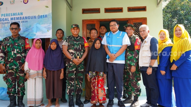 Dansatgas TMMD 128 Kodim 0623/Cilegon, Letkol Inf Imam Buchori (tengah) bersama warga penerima manfaat program RTLH dan perwakilan industri. [Hairul Alwan/Suara.com]