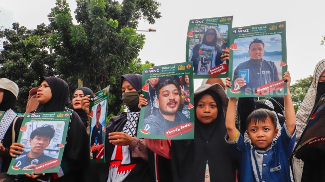 Massa yang berasal dari Aliansi kemanusiaan Aqsa Working Group (AWG) membawa poster bertema penculikan aktivis oleh zionis saat Aksi Jumat untuk Palestina di depan Kedutaan Besar Amerika Serikat, Jakarta, Jumat (22/5/2026). [Suara.com/Alfian Winanto]