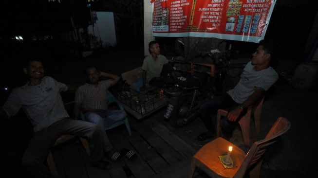 Sejumlah warga menunggu pasokan listrik kembali menyala dengan penerangan lilin saat terjadi pemadaman listrik di Banda Aceh, Aceh, Sabtu (23/5/2026). [Antara]