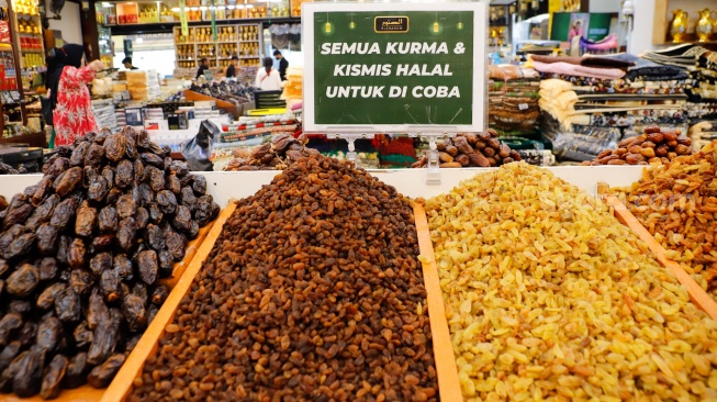 Penjual oleh-oleh haji dan umroh melayani calon pembeli kurma di Pasar Tanah Abang, Jakarta, Senin (25/5/2026). [Suara.com/Alfian Winanto]

