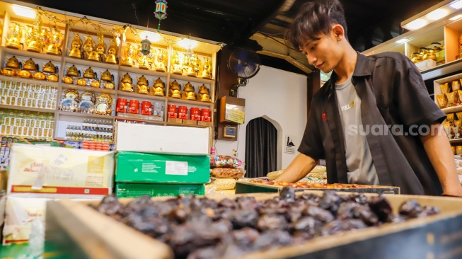 Penjual oleh-oleh haji dan umroh melayani calon pembeli kurma di Pasar Tanah Abang, Jakarta, Senin (25/5/2026). [Suara.com/Alfian Winanto]
