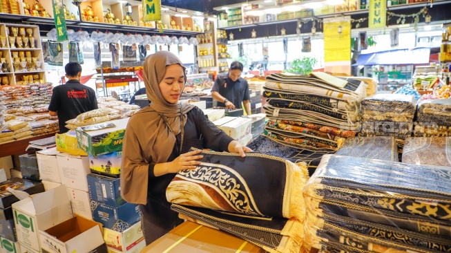 Penjual oleh-oleh haji dan umroh melayani calon pembeli kurma di Pasar Tanah Abang, Jakarta, Senin (25/5/2026). [Suara.com/Alfian Winanto]
