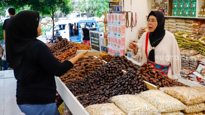 Penjual oleh-oleh haji dan umroh melayani calon pembeli kurma di Pasar Tanah Abang, Jakarta, Senin (25/5/2026). [Suara.com/Alfian Winanto]
