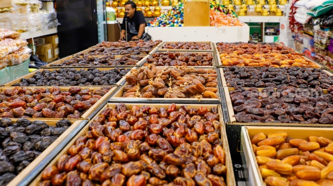 Penjual oleh-oleh haji dan umroh melayani calon pembeli kurma di Pasar Tanah Abang, Jakarta, Senin (25/5/2026). [Suara.com/Alfian Winanto]
