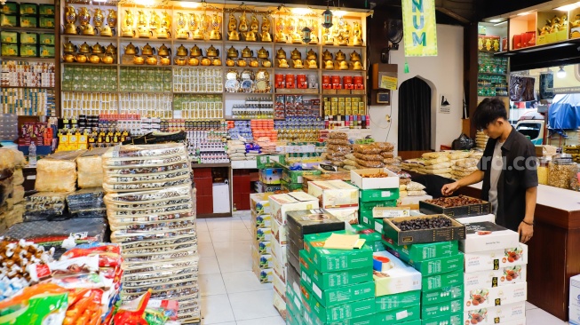 Penjual oleh-oleh haji dan umroh melayani calon pembeli kurma di Pasar Tanah Abang, Jakarta, Senin (25/5/2026). [Suara.com/Alfian Winanto]
