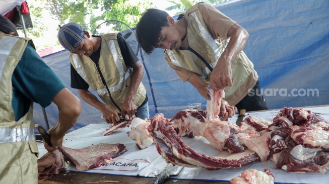 Petugas memotong daging hewan kurban di Masjid Sunda Kelapa, Jakarta, Rabu (27/5/2026). [Suara.com/Alfian Winanto]