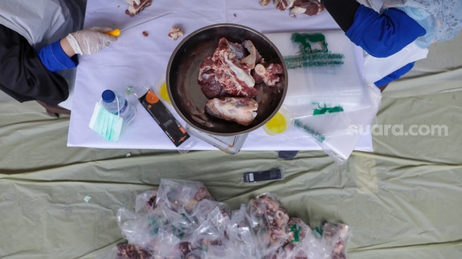 Petugas memotong daging hewan kurban di Masjid Sunda Kelapa, Jakarta, Rabu (27/5/2026). [Suara.com/Alfian Winanto]