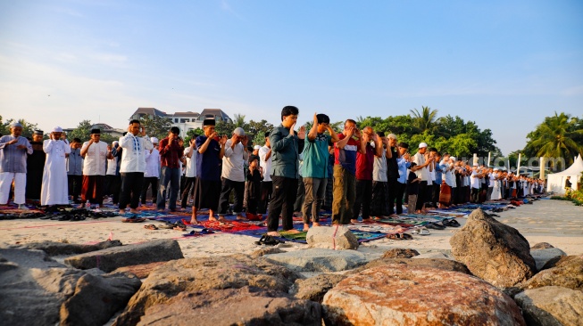 Umat Islam melaksanakan shalat Idul Adha 1447 H di Pantai Lagoon Ancol, Jakarta, Rabu (27/5/2026). [Suara.com/Alfian Winanto]