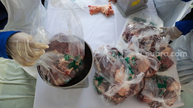 Petugas membagi daging hewan kurban kedalam plastik di Masjid Sunda Kelapa, Jakarta, Rabu (27/5/2026). [Suara.com/Alfian Winanto]