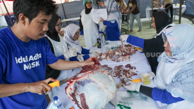 Petugas memotong daging hewan kurban di Masjid Sunda Kelapa, Jakarta, Rabu (27/5/2026). [Suara.com/Alfian Winanto]