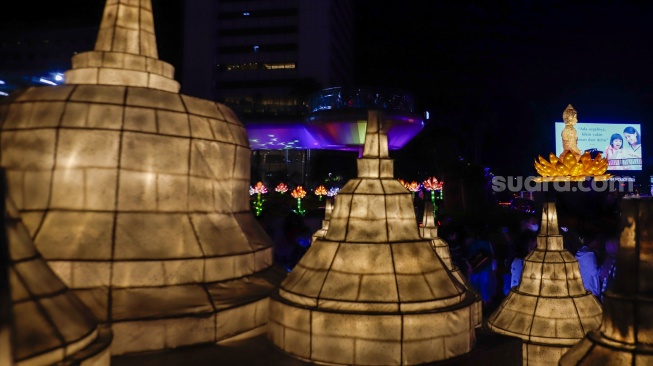 Warga melihat ornamen lampu hias saat llumination of Jakarta: Glow of Peace di kawasan Bundaran HI, Jakarta, Jumat (29/5/2026). [Suara.com/Alfian Winanto]