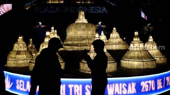 Warga melihat ornamen lampu hias saat llumination of Jakarta: Glow of Peace di kawasan Bundaran HI, Jakarta, Jumat (29/5/2026). [Suara.com/Alfian Winanto]