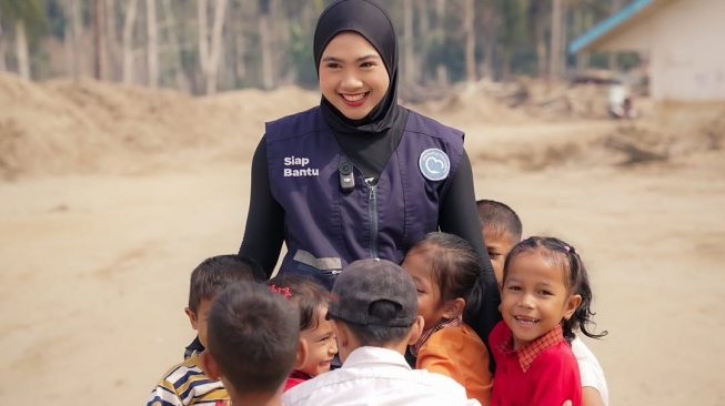 Afina Syifa Biladina bersama bocah di Aceh yang menjadi korban banjir bandang. [Instagram]