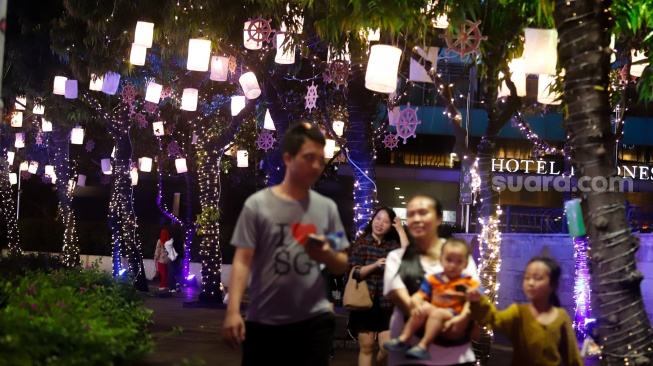 Warga melihat ornamen lampu hias saat llumination of Jakarta: Glow of Peace di kawasan Bundaran HI, Jakarta, Jumat (29/5/2026). [Suara.com/Alfian Winanto]
