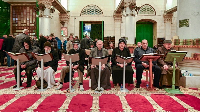 Umat Islam membaca kitab suci Al Quran sebelum melaksanakan salat Subuh di Masjid Qibli, kawasan Masjidil Aqsa, Kota Tua Al-Quds (Yerusalem), Palestina. [ANTARA FOTO/Muhammad Adimaja]