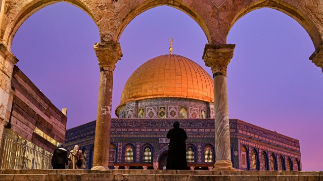 Umat Islam berjalan dengan latar belakang Masjid Kubah Shakhrah (Dome of The Rock) di kawasan Masjidil Aqsa, Kota Tua Al-Quds (Yerusalem), Palestina. [ANTARA FOTO/Muhammad Adimaja]