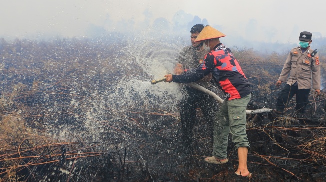 Personel Polres Aceh Barat melakukan upaya pemadaman dan pendinginan saat penanganan kebakaran hutan dan lahan (karhutla) di kawasan lahan gambut Desa Kuta Padang, Kecamatan Bubon, Aceh Barat, Aceh, Senin (1/6/2026). [ANTARA FOTO/Syifa Yulinnas/wsj]