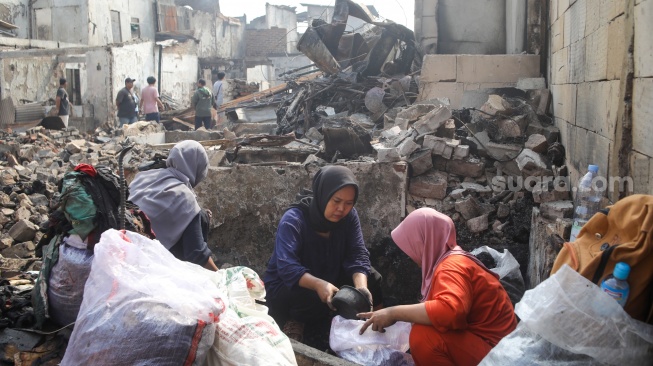 Warga mencari barang di rumahnya yang telah terbakar di kawasan Kebon Kosong, Kemayoran, Jakarta, Selasa (2/6/2026). [Suara.com/Alfian Winanto]
