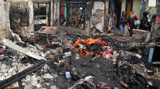 Warga mencari barang di rumahnya yang telah terbakar di kawasan Kebon Kosong, Kemayoran, Jakarta, Selasa (2/6/2026). [Suara.com/Alfian Winanto]
