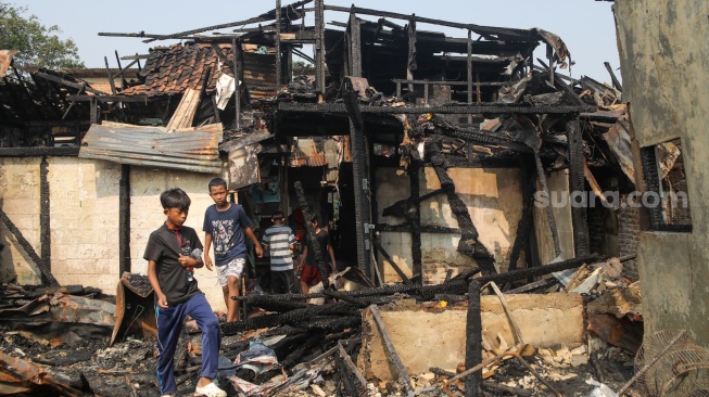 Warga mencari barang di rumahnya yang telah terbakar di kawasan Kebon Kosong, Kemayoran, Jakarta, Selasa (2/6/2026). [Suara.com/Alfian Winanto]

