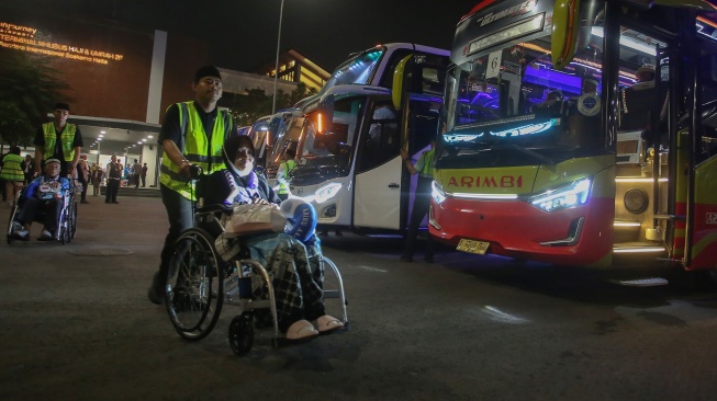 Petugas membantu jamaah haji kloter pertama asal DKI Jakarta menuju bus saat tiba di Terminal 2 F Khusus Haji dan Umrah Bandara Soekarno Hatta, Tangerang, Banten, Senin (1/6/2026). [ANTARA FOTO/Muhammad Iqbal/kye]