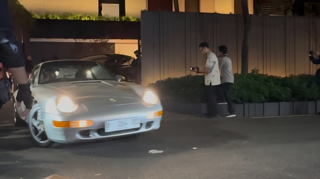 Mobil bermerek Porsche warna abu-abu keluar dari kediaman Silmy Karim di Jalan Brawijaya III No.5, Kebayoran Baru, Jakarta, Jumat malam (5/6/2026).  [Suara.com/Cornelius Juan]