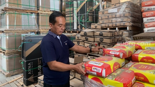 Owner toko bangunan TB Bersinar Jaya dan Dwi Jaya, Dwi Sudarmadi, ketika ditemui di gudang. (Suara.com/Irwan Febri)
