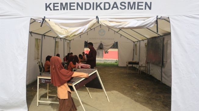 Seorang siswa Sekolah Dasar Negeri (SDN) Alue Lhok membawa meja sebelum mengikuti ujian di tenda darurat, di Desa Jambak, Kecamatan Pante Ceureumen, Aceh Barat, Aceh, Jumat (5/6/2026). [ANTARA FOTO/Syifa Yulinnas/kye]