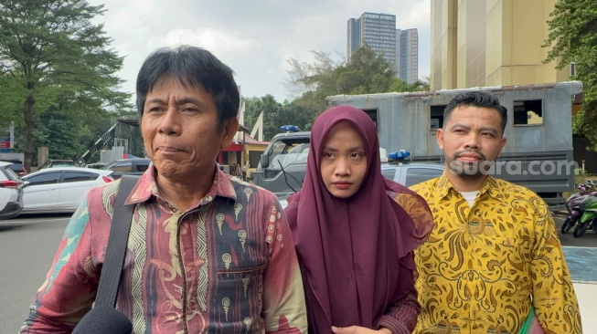 Nur Rohmah (tengah) bersama pengacaranya, Basuki (kiri) mendatangi Polres Metro Jakarta Selatan, Jumat (5/6/2026). Dalam pengakuannya, Nur mengaku sering mendapat kata-kata kasar berupa "tolol" dan "bego" dari majikannya, Erin Taulany. [Rena Pangesti/Suara.com]