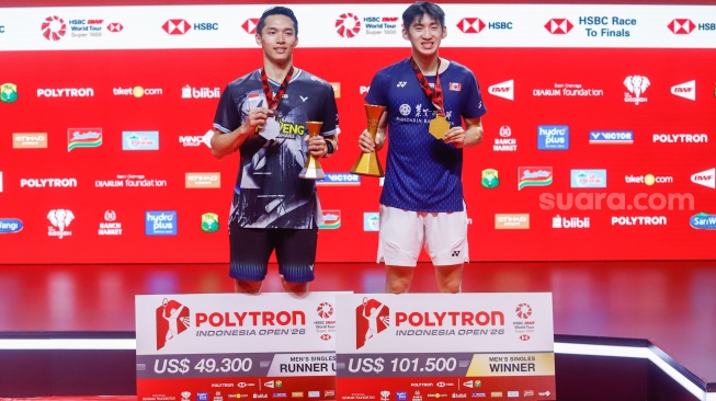 Pebulu tangkis tunggal putra Indonesia Jonatan Christie (kiri) dan tunggal putra Kanada Victor Lai (kanan) berpose dengan pialanya usai pertandingan final Polytron Indonesia Open 2026 di Istora Senayan, Jakarta, Minggu (7/6/2026). [Suara.com/Alfian Winanto]
