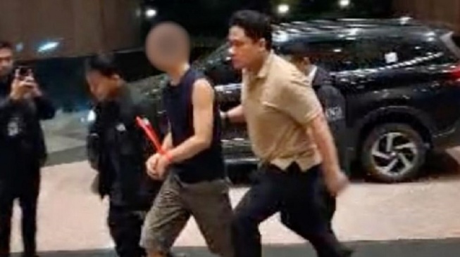 Petugas Imigrasi mengamankan WNA Amerika Serikat berinisial AW, buronan kasus pelecehan seksual di negaranya usai diamankan di sebuah bunker di kediamannya di daerah Sawangan, Depok, Jawa Barat, Kamis (23/4/2026). (ANTARA/HO-Humas Ditjen Imigrasi)