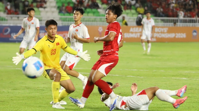 Pesepak bola Timnas Indonesia U-19 Fabio Azkairawan (tengah) mencoba menaklukkan penjaga gawang Vietnam U-19 Xuan Tin Hoa (kiri) pada pertandingan Piala AFF U-19 2026 di Stadion Utama Sumatera Utara, Kabupaten Deli Serdang, Minggu (7/6/2026). [ANTARA FOTO/Yudi Manar/Lmo/bar]
