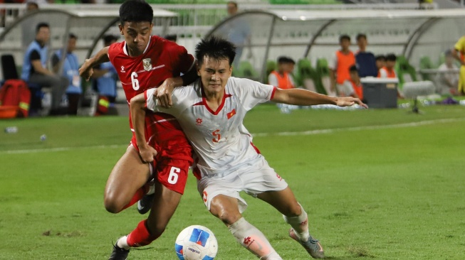 Pesepak bola Timnas Indonesia U-19 Evandra Florasta (kiri) berebut bola dengan pesepak bola Vietnam U-19 Tan Dung Le (kanan) pada pertandingan Piala AFF U-19 2026 di Stadion Utama Sumatera Utara, Kabupaten Deli Serdang, Minggu (7/6/2026). [ANTARA FOTO/Yudi Manar/Lmo/bar]