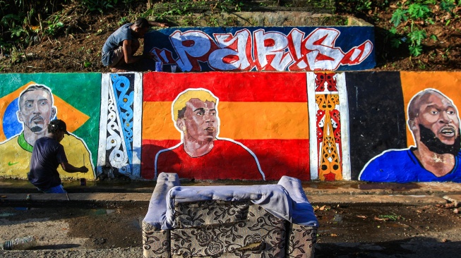 Warga melukis mural terkait Piala Dunia 2026 di Dok IX, Kelurahan Tanjung Ria, Jayapura Utara, Kota Jayapura, Papua, Senin (8/6/2026). [ANTARA FOTO/Gusti Tanati/sgd/wsj]