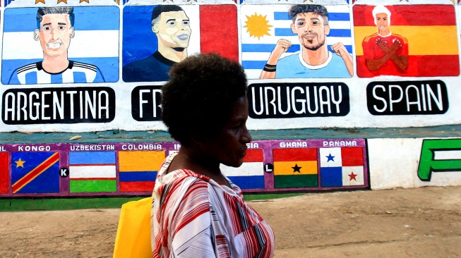 Warga melintas di dekat mural Piala Dunia 2026 di Dok IX, Kelurahan Tanjung Ria, Jayapura Utara, Kota Jayapura, Papua, Senin (8/6/2026). [ANTARA FOTO/Gusti Tanati/sgd/wsj]