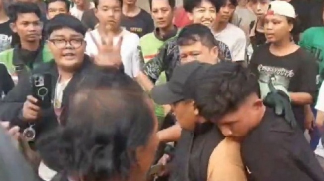 Seorang pemuda diamankan warga setelah diduga melakukan penipuan dengan membeli sepeda motor menggunakan uang palsu senilai Rp12 juta di Jalan Pahlawan Revolusi, Pondok Bambu, Duren Sawit, Jakarta Timur, Kamis (11/6/2026). [ANTARA/Siti Nurhaliza]