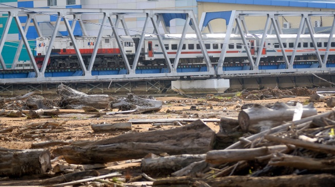 Kereta api melintas di jembatan dekat sisa material banjir bandang yang masih menutupi lapangan sepak bola Brandon di Lapai, Padang, Sumatera Barat, Rabu (10/6/2026). [ANTARA FOTO/Fitra Yogi/bar]