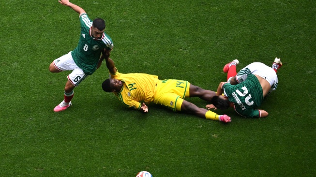 Pesepak bola Tim Nasional Afrika Selatan Mbekezeli Mbokazi (tengah) terjatuh saat berebut bola dengan dua pesepak bola Tim Nasional Meksiko Erik Lira (kiri) dan Roberto Alvarado dalam laga pembuka Grup A Piala Dunia 2026 di Stadion Azteca, Mexico City, Meksiko, Kamis (11/6/2026). [ANTARA FOTO/Aditya Pradana Putra/sgd]
