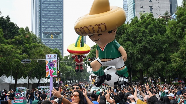Sejumlah warga menyaksikan balon udara karakter maskot Piala Dunia 1970 Juanito dan maskot Piala Dunia 1986 Pique dalam Gran Desfile Mundialista atau Parade Akbar Piala Dunia 2026 di Paseo de la Reforma, Mexico City, Meksiko, Sabtu (13/6/2026) waktu setempat. [ANTARA FOTO/Aditya Pradana Putra/kye]