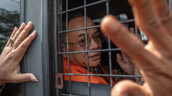 Bupati Pati nonaktif Sudewo menyapa pendukungnya dari dalam mobil tahanan seusai menjalani sidang perdana pembacaan dakwaan di Pengadilan Tipikor Semarang, Jawa Tengah, Senin (15/6/2026). [ANTARA FOTO/Aji Styawan/nym]