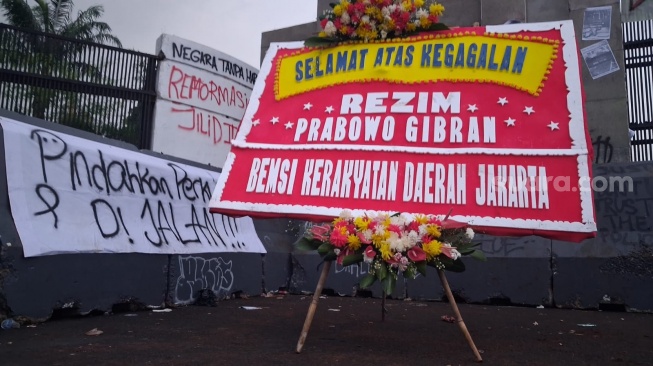 Dua karangan bunga dari Badan Eksekutif Kerakyatan Daerah Jakarta dipasang di area depan Gedung DPR RI, Senayan, Jakarta, Senin petang (15/6/2026). (Suara.com/Juan)