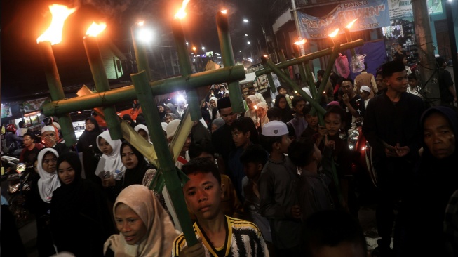 Sejumlah warga mengikuti pawai obor dan dondang di Cikiwul, Bantargebang, Bekasi, Jawa Barat, Senin (15/6/2026). [ANTARA FOTO/Darryl Ramadhan/bar]
