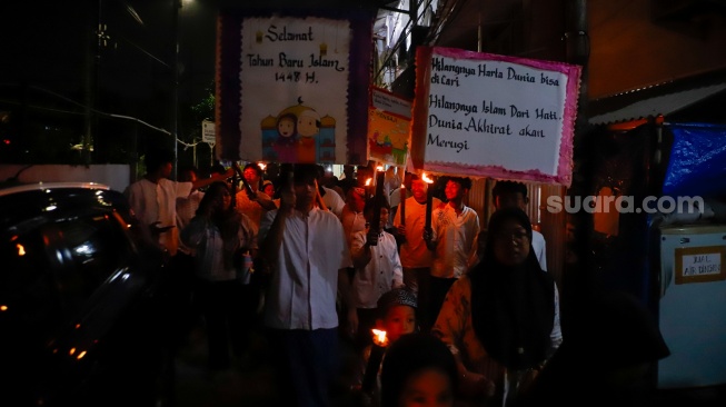 Sejumlah warga dan anak-anak mengikuti pawai obor di Kawasan Menteng, Jakarta Pusat, Senin (15/6/2026).  [Suara.com/Alfian Winanto]