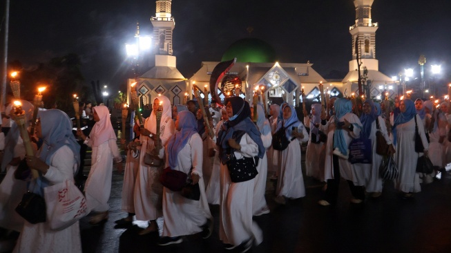 Sejumlah warga mengikuti pawai obor di Jalan Raya Tegar Beriman, Cibinong , Kabupaten Bogor, Jawa Barat, Senin (15/6/2026). [ANTARA FOTO/Yulius Satria Wijaya/bar]