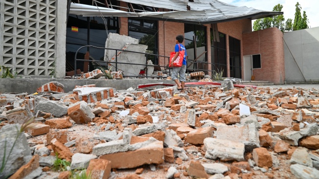 Seorang anak memperhatikan bangunan yang mengalami kerusakan akibat gempa di Palu, Sulawesi Tengah, Selasa (16/6/2026). [ANTARA FOTO/Basri Marzuki/Lmo/YU]