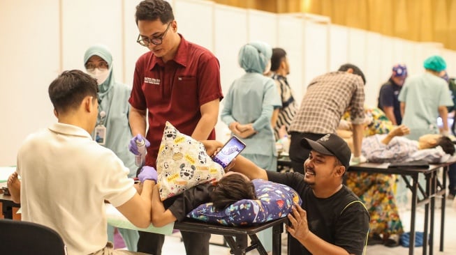Orang tua menemani anaknya saat proses sunat massal di Mal Kota Kasablanka, Jakarta, Selasa (16/6/2026). [Suara.com/Alfian Winanto]