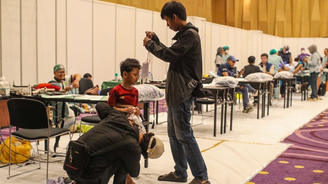 Orang tua melihat kondisi anaknya sebelum proses sunat massal di Mal Kota Kasablanka, Jakarta, Selasa (16/6/2026). [Suara.com/Alfian Winanto]