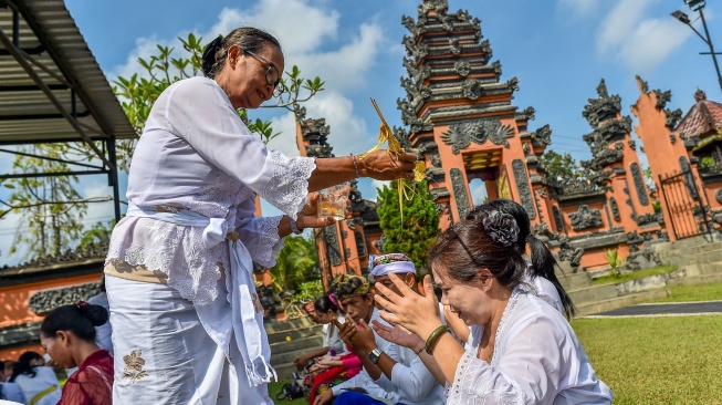 Umat Hindu menerima percikan air suci saat persembahyangan Hari Raya Galungan di Pura Giri Indra Lokha, Kota Baru, Jambi, Rabu (17/6/2026). [ANTARA FOTO/Wahdi Septiawan/bar]