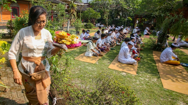 Seorang umat Hindu membawa sesajen saat mengikuti upacara persembahyangan perayaan Hari Raya Galungan di Pura Amerta Jati, Cinere, Depok, Jawa Barat, Rabu (17/6/2026). [ANTARA FOTO/Muhammad Iqbal/wsj]