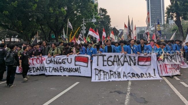 Massa aksi dari Pergerakan Mahasiswa Islam Indonesia (PMII) dan Gerakan Mahasiswa Kristen Indonesia (GMKI) menyampaikan pendapat di kawasan Patung Kuda, Jakarta Pusat, Kamis (18/6/2026). [Suara.com/Adiyoga]